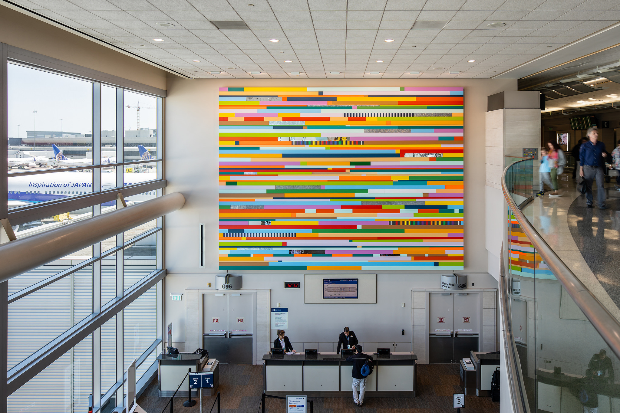 large multi-colored two-dimensional artwork, hanging in airport check-in terminal