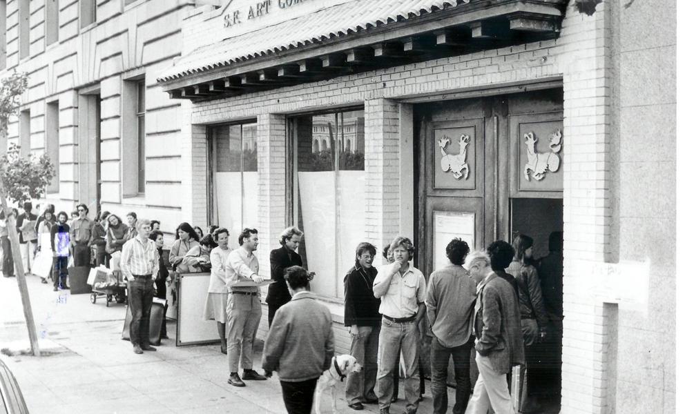 Archival photograph of 155 Grove Street in the 70s. Images shows the storefront with a line of people waiting to get in. 